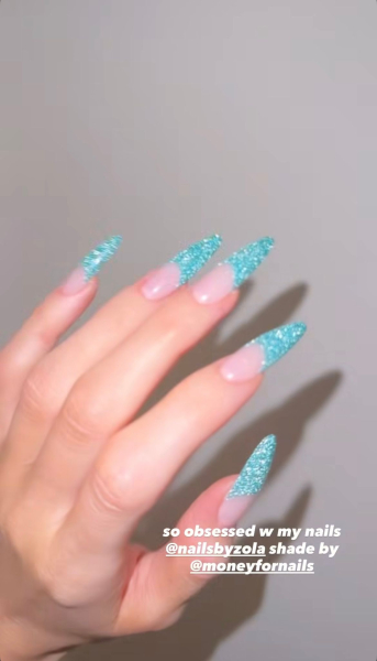 Kylie Jenner wears long nails with sparkling turquoise French tips.